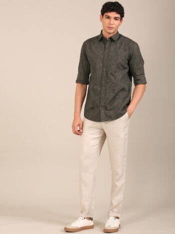 Men’s dark olive leaf print shirt styled with beige trousers outdoors